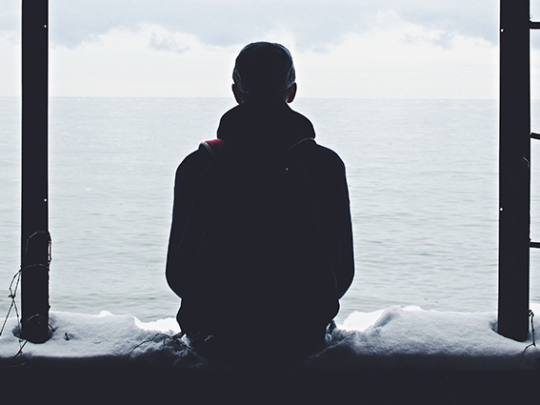 A man sitting alone. Your loneliness in a big world